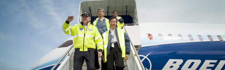 A group of workers in high visibilty vests walking down a jet stairway